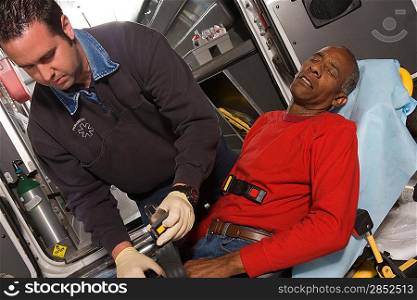 Paramedic helping man in ambulance