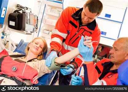 Paramedics measuring blood pressure to patient ambulance feeling in pain