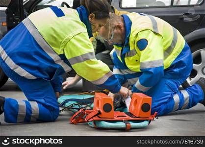 Paramedics preparing a stretcher for a wounded car accident victim