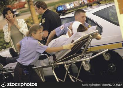 Paramedics putting a patient into an ambulance