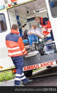 Paramedics putting patient man oxygen mask in ambulance car