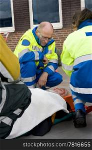 Paramedics tending to an injured woman on a stretcher wearing a neck brace