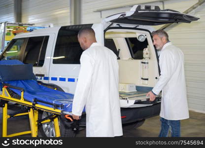 Paramedics wheeling stretcher to ambulance