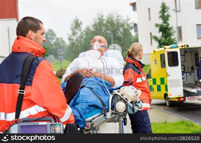 Paramedics with patient on emergency stretcher ambulance aid woman man