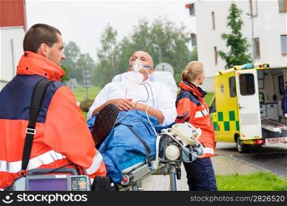 Paramedics with patient on emergency stretcher ambulance aid woman man