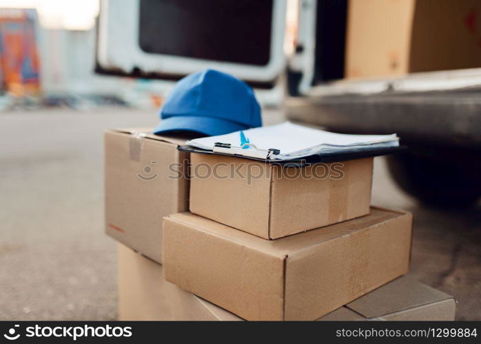 Parcel boxes and cap with notebook, delivery service concept, delivering business, nobody. Cardboard packages, deliver, courier or shipping job. Parcel boxes and cap, delivery service concept