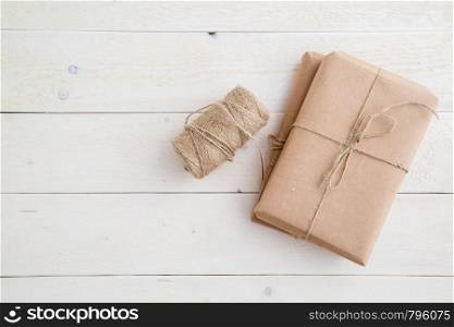 parcel,gift Packed in eco-friendly paper and twine for packing on light wooden background. the view from the top