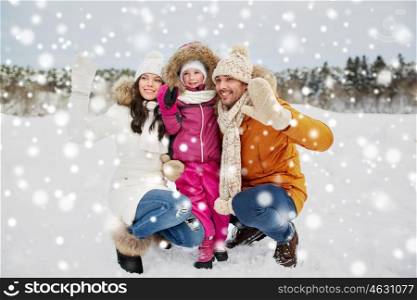 parenthood, fashion, gesture, season and people concept - happy family with child in winter clothes waving hands outdoors