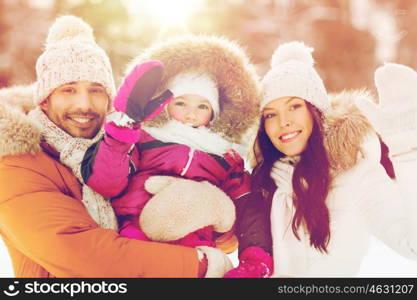 parenthood, fashion, gesture, season and people concept - happy family with child in winter clothes waving hands outdoors