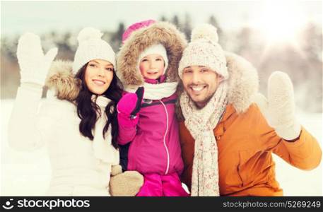 parenthood, fashion, gesture, season and people concept - happy family with child in winter clothes waving hands outdoors. happy family waving hands outdoors in winter