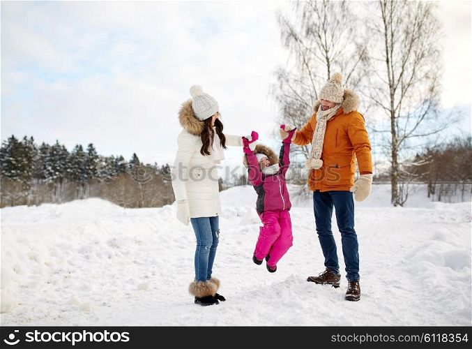 parenthood, fashion, season and people concept - happy family with child in winter clothes walking and having fun outdoors