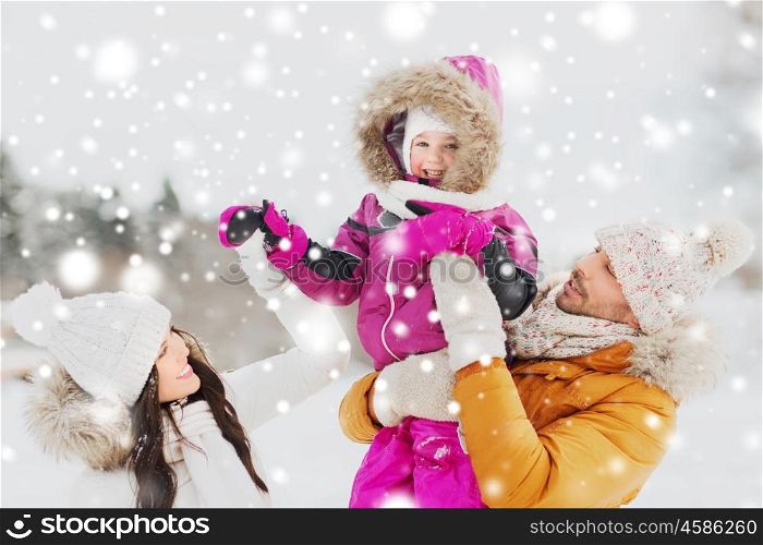 parenthood, fashion, season and people concept - happy family with child in winter clothes outdoors
