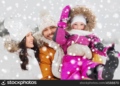 parenthood, fashion, season and people concept - happy family with child in winter clothes outdoors