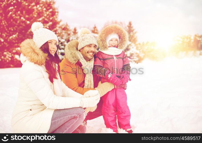 parenthood, fashion, season and people concept - happy family with child in winter clothes outdoors