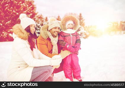 parenthood, fashion, season and people concept - happy family with child in winter clothes outdoors