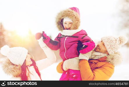 parenthood, fashion, season and people concept - happy family with child in winter clothes outdoors