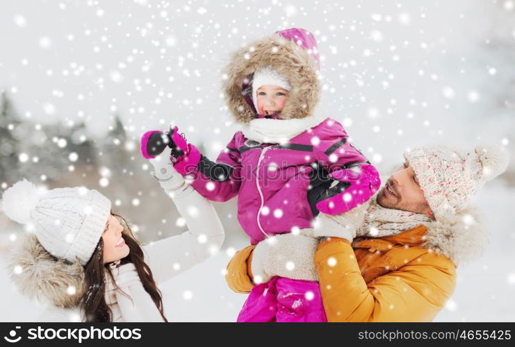 parenthood, fashion, season and people concept - happy family with child in winter clothes outdoors