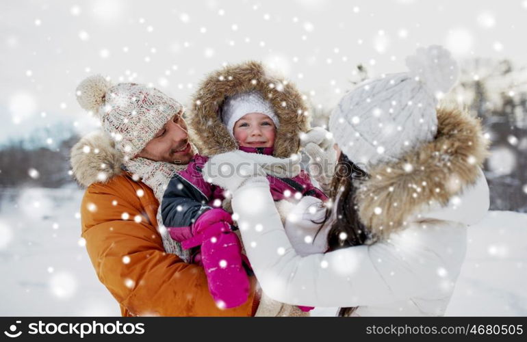 parenthood, fashion, season and people concept - happy family with child in winter clothes outdoors