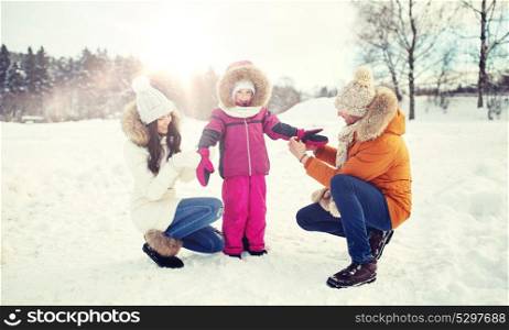 parenthood, fashion, season and people concept - happy family with child in winter clothes outdoors. happy family with child in winter clothes outdoors