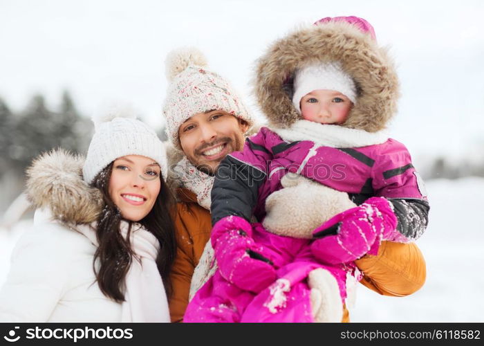 parenthood, fashion, season and people concept - happy family with child in winter clothes outdoors