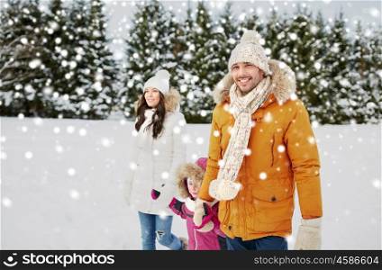 parenthood, fashion, season and people concept - happy family with child in winter clothes walking outdoors