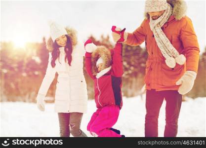parenthood, fashion, season and people concept - happy family with child in winter clothes walking outdoors