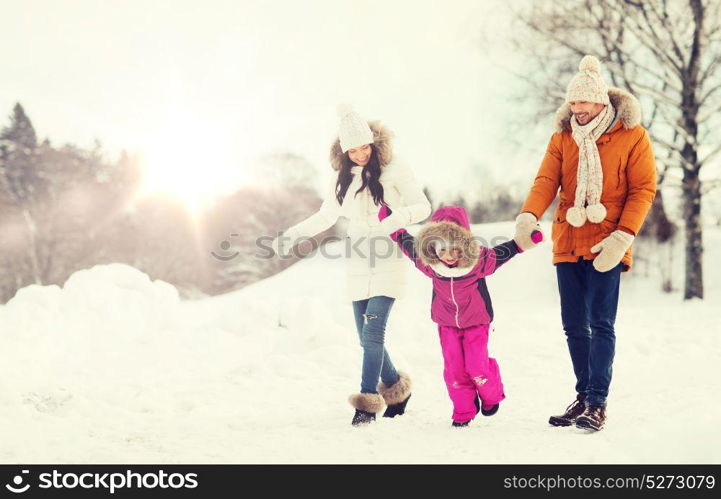 parenthood, fashion, season and people concept - happy family with child in winter clothes walking outdoors. happy family in winter clothes walking outdoors