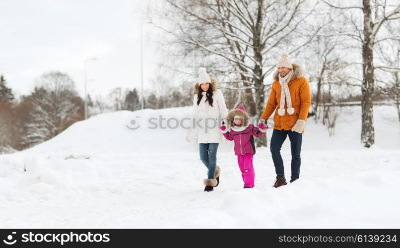 parenthood, fashion, season and people concept - happy family with child in winter clothes walking outdoors