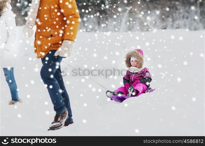 parenthood, fashion, season and people concept - happy family with child on sled walking in winter forest
