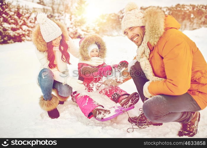 parenthood, fashion, season and people concept - happy family with child on sled having fun outdoors