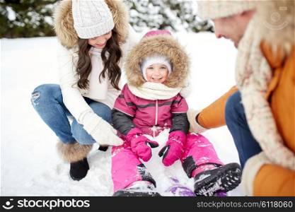 parenthood, fashion, season and people concept - happy family with sled walking in winter outdoors
