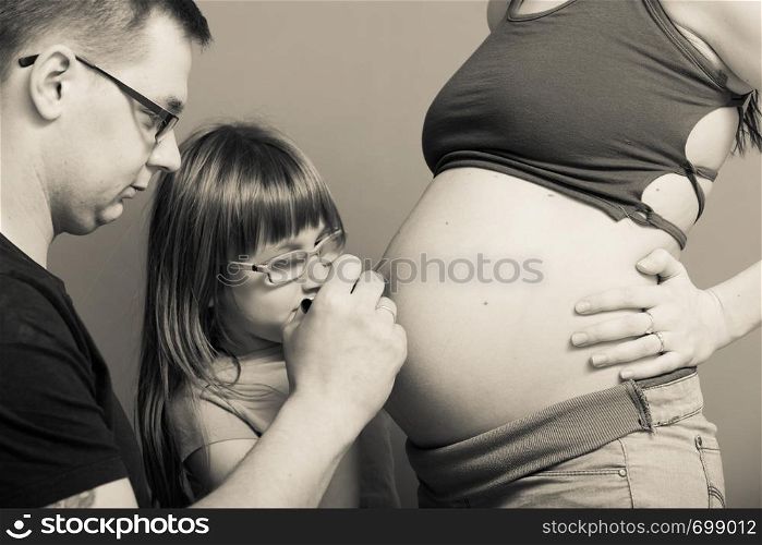 Parenthood, waiting for baby concept. Pregnant woman big belly with drawings made by father and daughter. Pregnant woman belly, father drawing on stomach