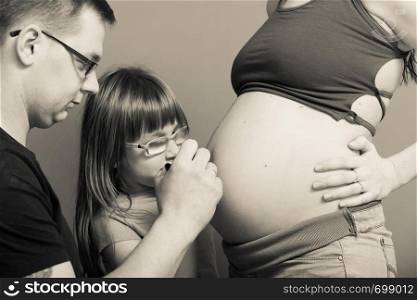 Parenthood, waiting for baby concept. Pregnant woman big belly with drawings made by father and daughter. Pregnant woman belly, father drawing on stomach