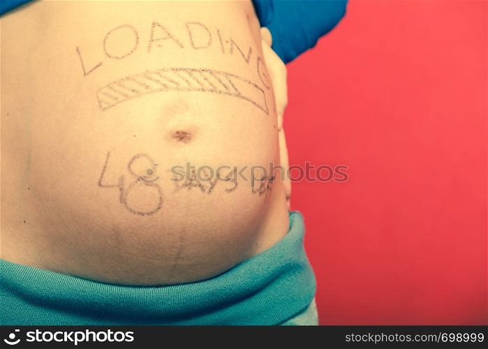 Parenthood, waiting for baby concept. Pregnant woman big belly with loading drawing. Pregnant woman belly with drawings