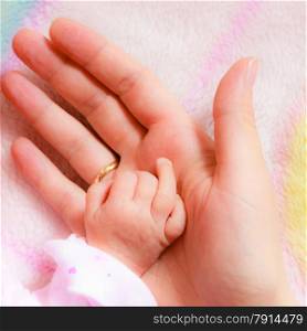 Parenting and love concept. Closeup newborn baby holding his mothers finger. Square format