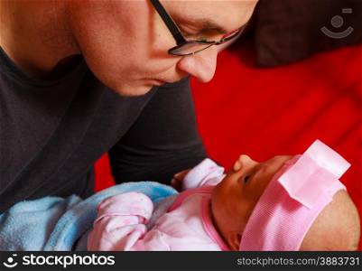 Parenting concept. Father holding delicate his newborn baby girl, at home