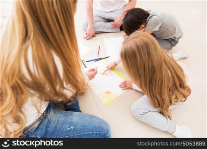 Parents and children drawing. Parents and children drawing with pencils on the floor