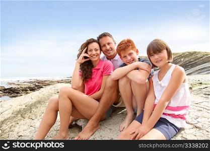 Parents and children sitting by the sea