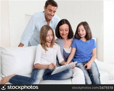 Parents and children using electronic tablet at home