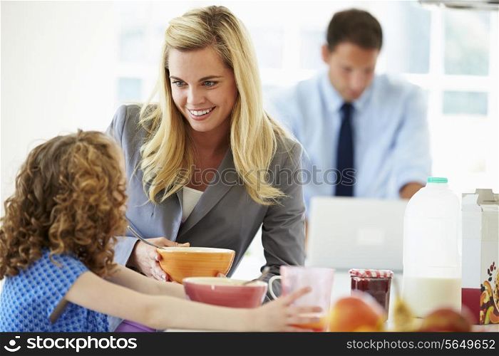 Parents And Daughter Having Breakfast In Kitchen Together