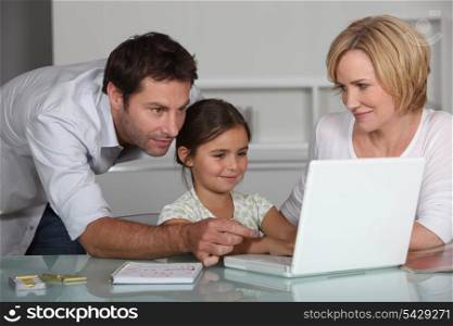 Parents and daughter on laptop