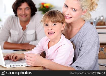 Parents and daughter using a laptop computer