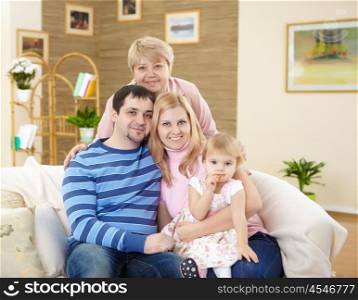 parents and his little daughter together with grandmother at home