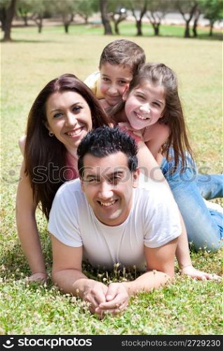 Parents and kids lying in the grass field in park,outdoor
