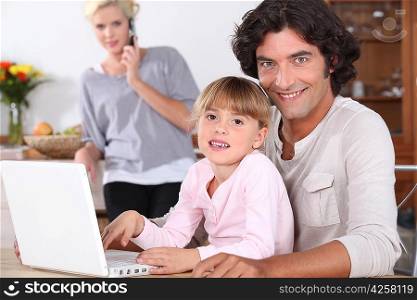 Parents and little girl with laptop