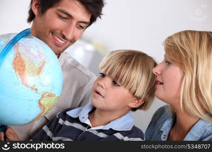 Parents and son looking at a globe