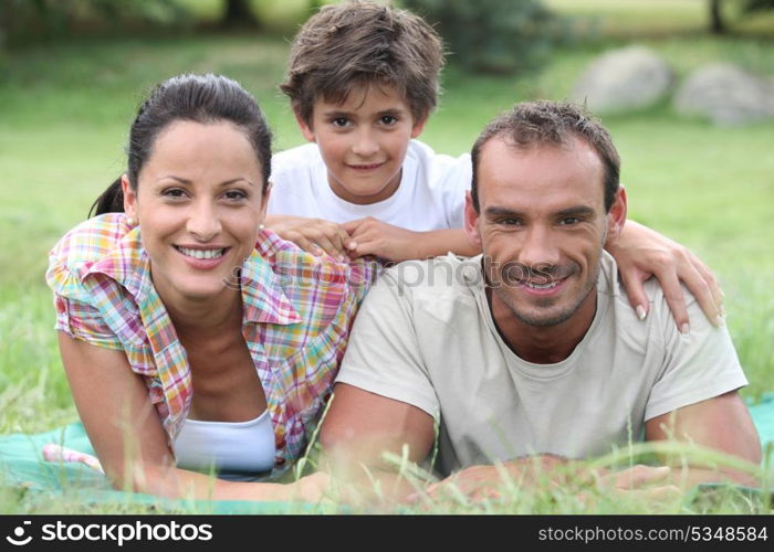 Parents and son lying on the grass