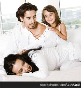 Parents and their daughter on the bed