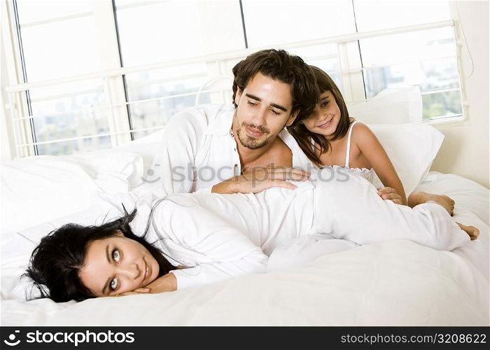Parents and their daughter on the bed