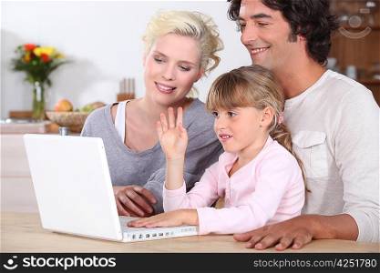 parents and their little girl having fun on the Internet